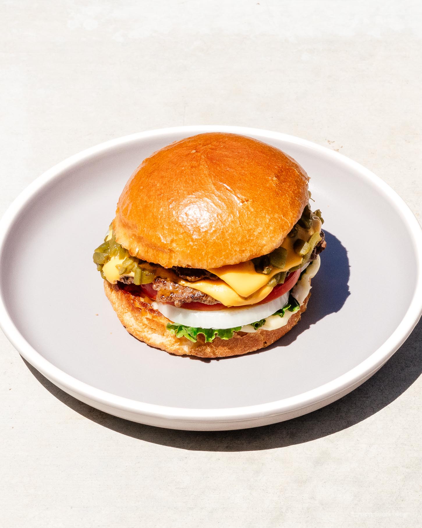A Hatch green chile cheeseburger might be the best thing from New Mexico. Super juicy, slightly spicy, and oh so addictive. This is the burger recipe you want to be making right now. #burger #burgerrecipe #recipes #dinner #dinnerrecipes #cheeseburger #newmexico